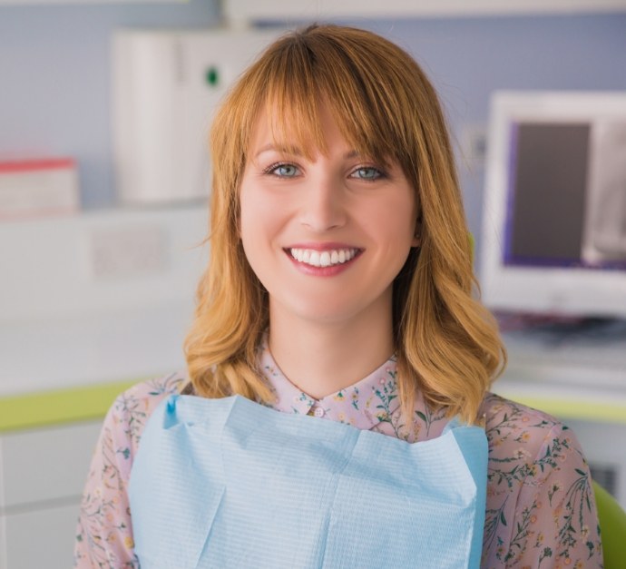 Smiling young woman sitting in dental chair