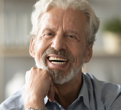 Older patient in Richardson smiling with dental implants