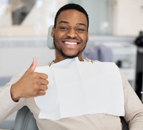 Happy dental patient making thumbs-up gesture