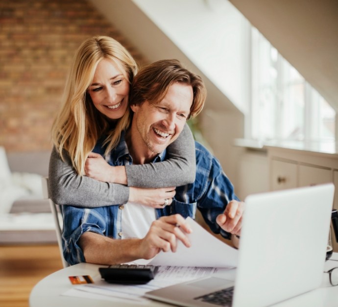 Man and woman looking at laptop together for oral surgery dentist reviews