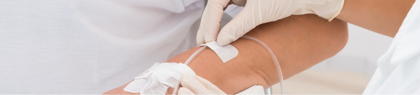 Sedation dentist adjusting an I V on the arm of a patient