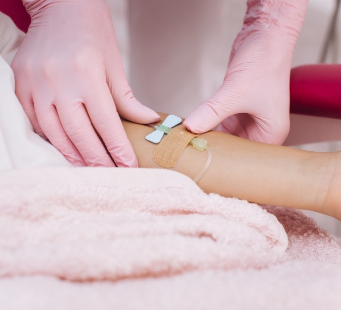 Dental team member adjusting the I V on the arm of a patient