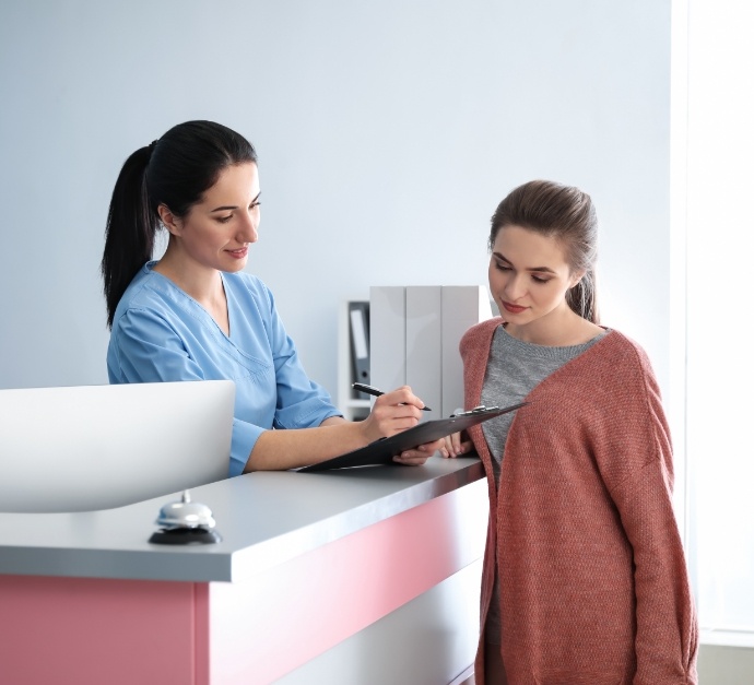 Dental team member showing a clipboard to a patient